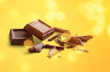 Broken chocolate bar on background