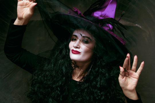 Beautiful young woman in witches hat and costume