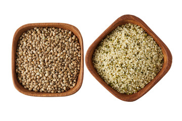 Organic whole and shelled hemp seeds in wooden bowl  isolated on white background
