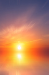 Beautiful orange sea sunset with bright sun and clouds.