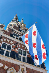 Frisian flag on the old renaissance style town hall in Franeker Friesland The Netherlands under a blue sky with copy space. Vertical image.     