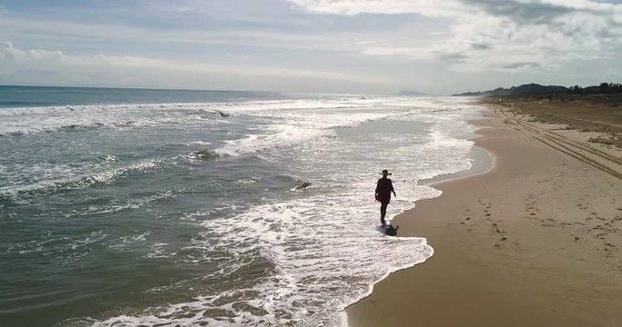 Mujer con pamela pasea en solitario en playa paradisiaca