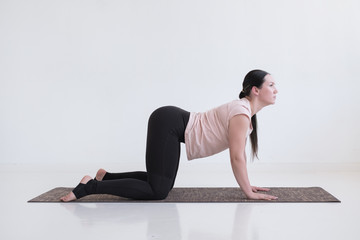 Woman doing yoga asana bitilasana cow or cat pose for gentle warm up for spine
