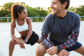 Photo of multinational focused couple doing exercise together