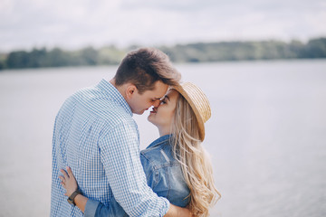 Fototapeta premium beautiful long-haired blonde with her handsome man wallkinh near water on the beach