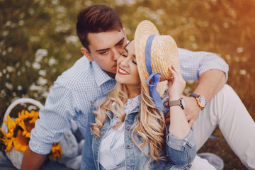 beautiful long-haired blonde with her handsome man sitting in the park with fruits