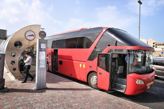 DUBAI, UAE - DECEMBER 10, 2017: People wait at air conditioned bus stop in Dubai, UAE. Dubai is the most populous city in UAE and a major global city.