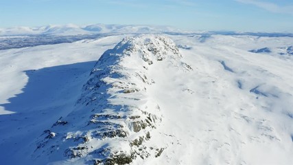 Sweden, drone flying sunny winter day along mountain ridge in Northern Sweden. Breathtaking view over Scandinavian Mountains, Lappland.