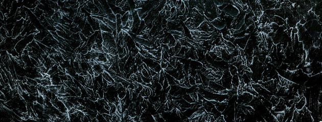 Fototapeta na wymiar Black texture background in the form of a panorama. Abstract cracks. Black texture background with white cracks and veins. Textural wallpaper for design and decoration.