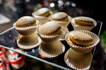 Chocolate macaroons cakes on a black background. Macaroons on black surface