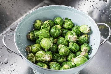 washing raw Brussels sprouts in kitchen sink