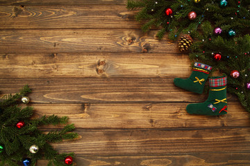 Fir tree branches with Christmas decoration and Santa gift socks against old vintage style wooden planks. Christmas/New Year concept. Christmas card theme.