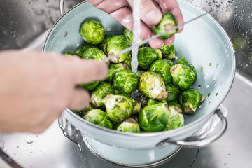 washing raw Brussels sprouts in kitchen sink
