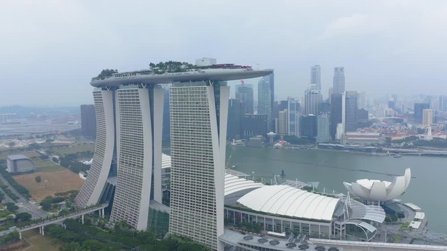Travelling aerial shot of Marina Bay Sands with Singapore City Skyline as background during Cloudy day