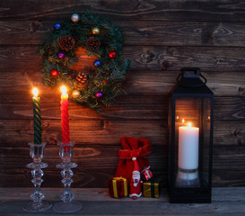 Christmas candles and decorations with toy Santa Claus in dark interior.Cristmas concept. New Year concept. Cristmas background.