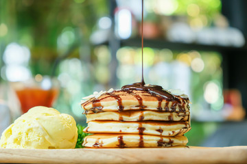Sweet banana pancakes with vanilla ice cream and chocolate syrup.