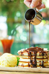 Sweet banana pancakes with vanilla ice cream and chocolate syrup.
