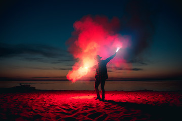 Man with signal fire or fireworks in hands
