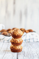 Beautiful fresh baked homemade pumpkin muffins stack on top of each other against a white background. Selective focus on bread in front with blurred background.