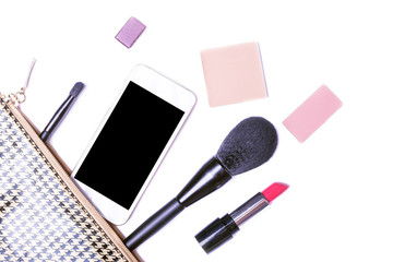 Makeup brushes and decorative cosmetics spilling out over a white background, top view.