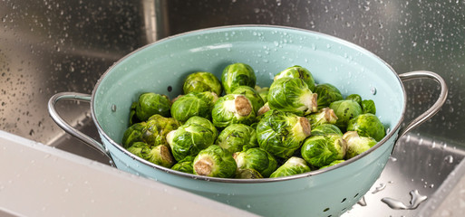 washing raw Brussels sprouts in kitchen sink