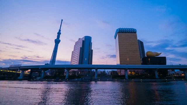 Day to night time lapse of Tokyo skyline on the Sumida River with sunrise, Japan