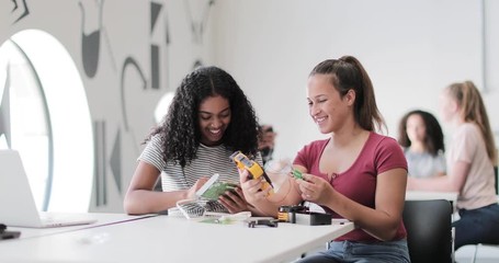 High school students working on a robotic arm in class