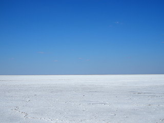 white surface of the lake covered with salt at sunrise