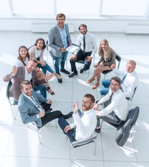 business training participants sitting in a circle and looking at the camera