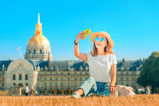 Asian happy girl traveler taking selfie pictures in the square near the Invalides In Paris. Lifestyle and tourism in France