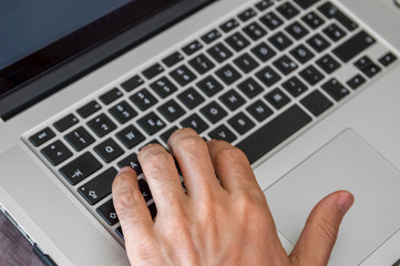 Freelancer typing on laptop computer keyboard