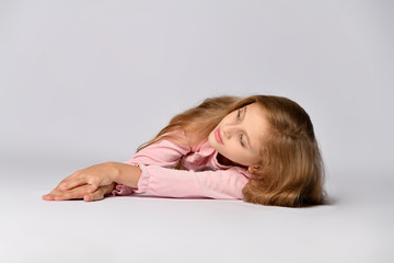 Fototapeta premium Portrait of a young woman lying on the floor isolated on white background