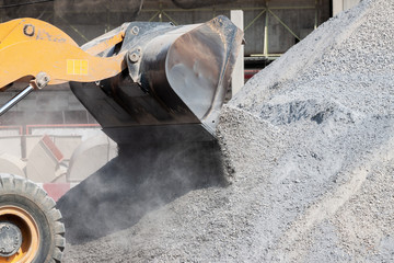 Excavator loads gravel in a heavy mining truck.