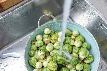 washing raw Brussels sprouts in kitchen sink