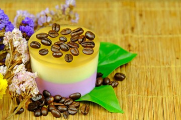 Coffee custard jelly with coffee bean placed on top decorated with green leaves, coffee bean and colorful Statice or Caspia flower on bamboo mat. on bamboo mat.