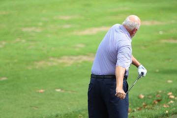 senior golfer stretches prior to practicing