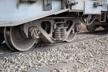 Naklejka premium Closed Up to Cargo Train Car Undercarriage in Railroad with Stones
