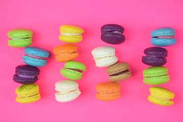 French colorful macarons on pink background 
