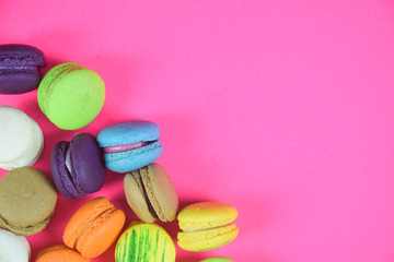 French colorful macarons on pink background 