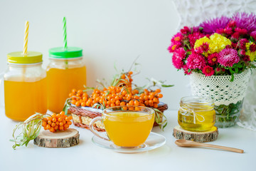 White background, natural lighting. Warm sweet organic tea with sea buckthorn berries, thyme and honey.