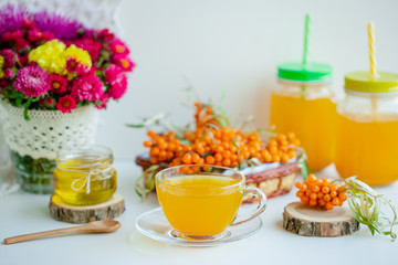 White background, natural lighting. Warm sweet organic tea with sea buckthorn berries, thyme and honey.