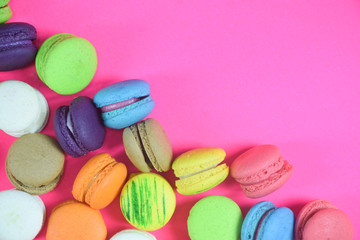 French colorful macarons on pink background 