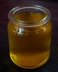 Clarification of butter. Jar full of clarified butter on a black isolated background.
