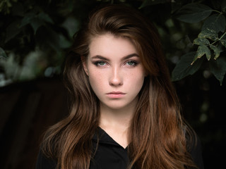 Closeup headshot of a beautiful serious caucasian red haired woman with adorable freckles...