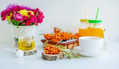 White background, natural lighting. Warm sweet organic tea with sea buckthorn berries, thyme and honey.