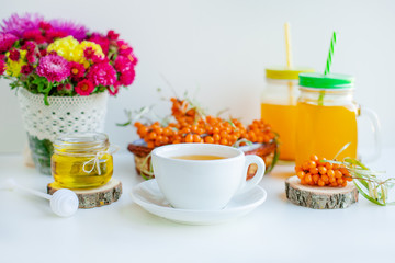 White background, natural lighting. Warm sweet organic tea with sea buckthorn berries, thyme and honey.