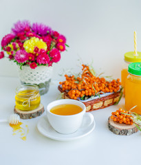 White background, natural lighting. Warm sweet organic tea with sea buckthorn berries, thyme and honey.