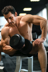 Fototapeta na wymiar Shirtless bodybuilder with dumbbell. Workout bodybuilding concept. 