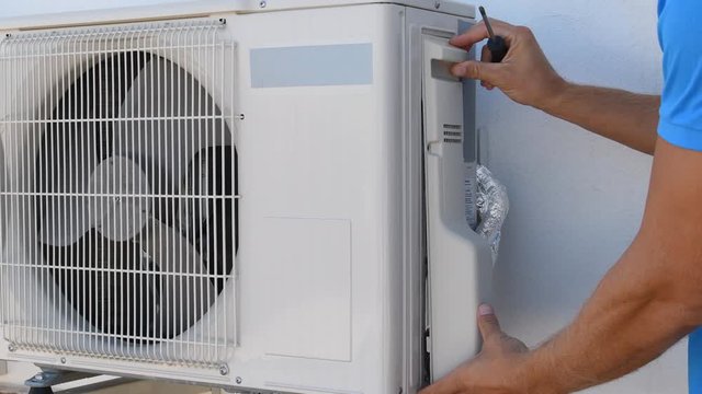 Professional repairman connects and repairs air conditioning