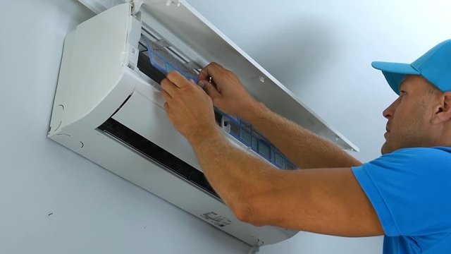 Professional repairman connects and repairs air conditioning